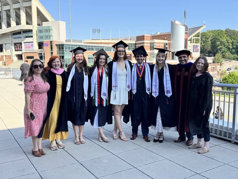 Graduating students together on campus.
